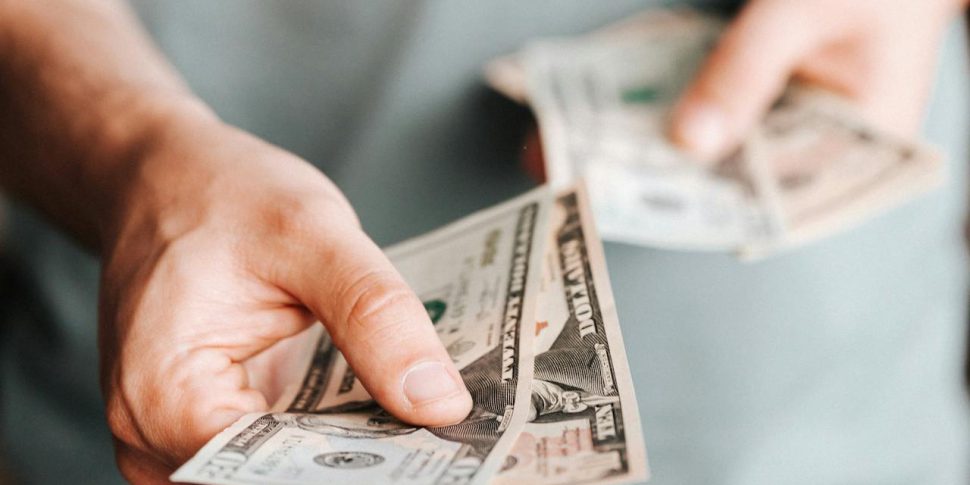 A person paying with cash bills